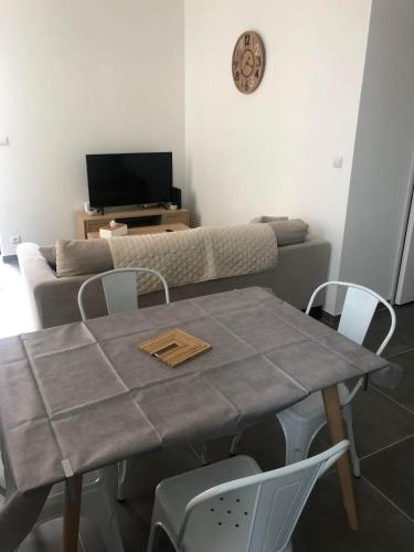 a table and chairs in a living room with a couch at Montbard appartements au centre historique chez Delphine et Guillaume in Montbard