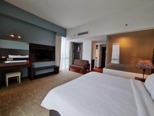 a hotel room with a bed and a television at Swan Garden Hotel in Melaka