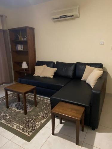 a living room with a blue couch and two tables at Paralimni in Paralimni