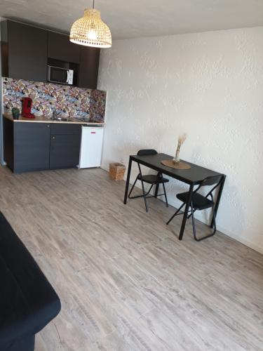 ein Esszimmer mit einem Tisch und einer Küche in der Unterkunft Studio spacieux plage in Fos-sur-Mer