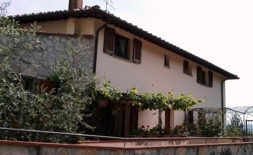 une maison avec une clôture et des arbres devant elle dans l'établissement Vicino circuito Mugello, Panoramico con piscina, à Bovecchio