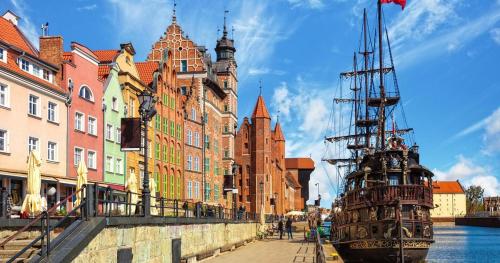 un barco en el agua junto a los edificios en AL Mare Apartament, en Gdansk