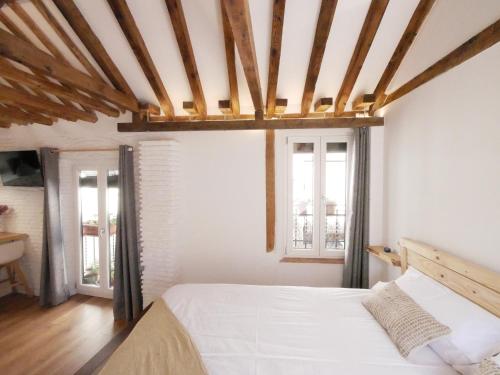 een slaapkamer met een wit bed en 2 ramen bij Baños del Agua in Granada