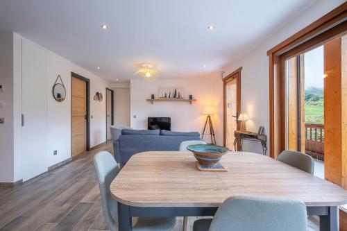 une salle à manger avec une table et un canapé bleu dans l'établissement Le Samance 1, au Grand-Bornand
