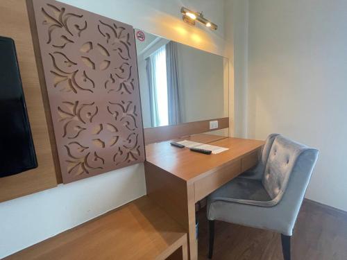 a desk with a mirror and a chair in a room at Swan Garden Hotel in Melaka