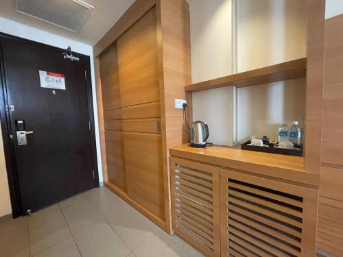 a kitchen with a counter and a door in a room at Swan Garden Hotel in Melaka