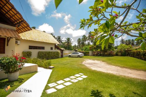 a driveway to a house with a car parked in the yard at Pousada Yapara-Tyba in Japaratinga