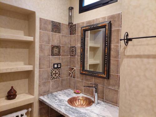 La salle de bains est pourvue d'un lavabo et d'un miroir. dans l'établissement Riad Dades Paradise, à Boumalne