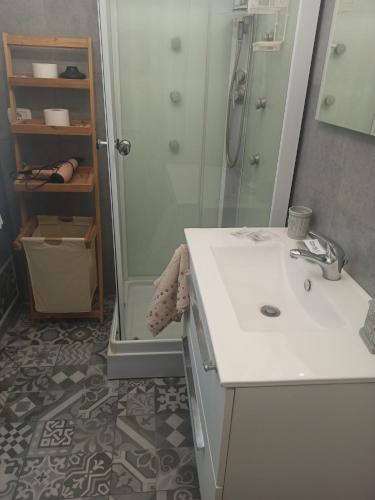 een badkamer met een wastafel en een douche bij Casa Otello in Siracusa