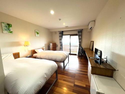 a hotel room with two beds and a television at South Sea Ishigaki in Ishigaki Island