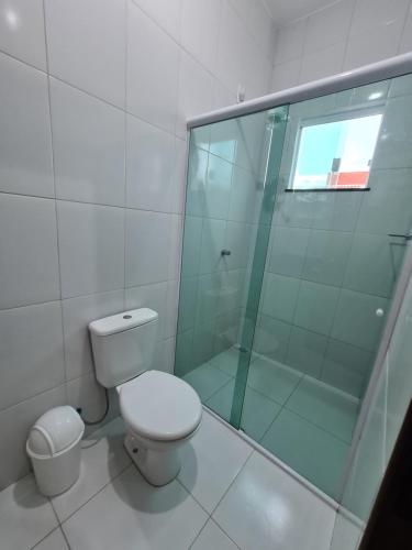 La salle de bains est pourvue de toilettes et d'une douche en verre. dans l'établissement Casa 22 Lençóis Maranhenses - Barreirinhas - MA, à Barreirinhas