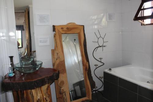 ein Badezimmer mit einem Spiegel und einer Badewanne in der Unterkunft Loma de las Maravillas in Curacaví