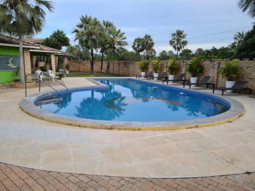 een zwembad op een patio met stoelen eromheen bij Casa 22 Lençóis Maranhenses - Barreirinhas - MA in Barreirinhas