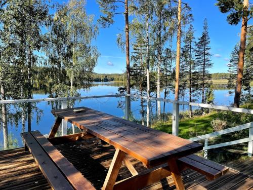 a picnic table on a dock near a lake at Tarula Holiday Home in Melkoniemi
