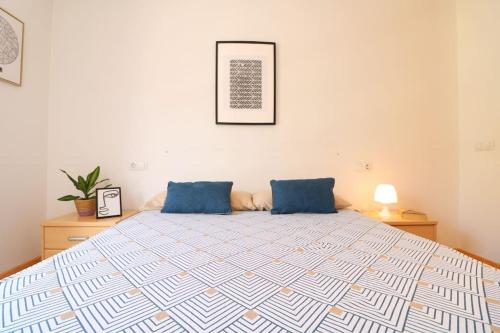 1 dormitorio con 1 cama grande con almohadas azules en Espectacular vivienda con piscina climatizada, en Castellón de la Plana