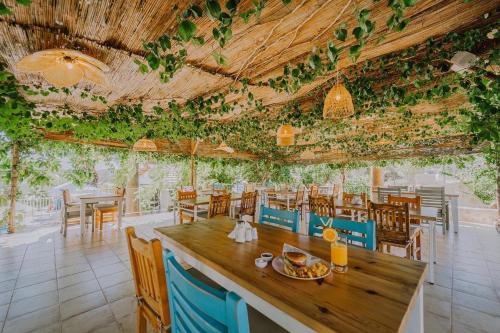 a dining room with a table and chairs and plants at Golden Lighthouse Hotel in Patara
