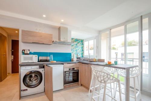 une cuisine avec un lave-linge et un lave-vaisselle dans l'établissement Atmosphere Cosy Grange-Blanche : balcon et calme, à Lyon