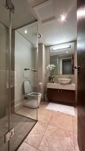a bathroom with a shower and a toilet and a sink at Canal Quays 507 in Cape Town