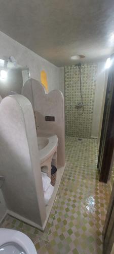 a bathroom with a toilet and a sink at Maison Vallée Du Ziz in Ouled Aissa