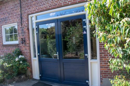 una puerta delantera azul de una casa de ladrillo en B&B Kelpiebrink en Baarle-Nassau