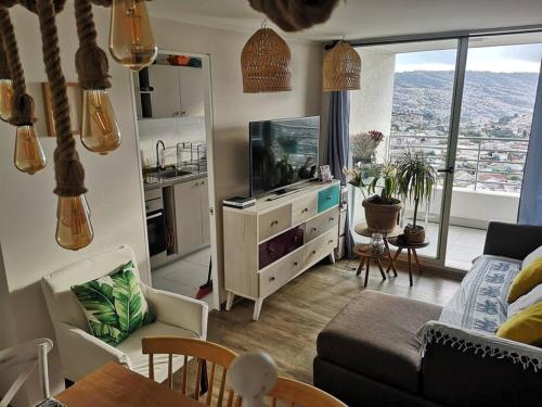 un soggiorno con divano e TV e una cucina di Depto Valparaíso con Vista al Mar y a la Bahía de Valparaíso a Viña del Mar