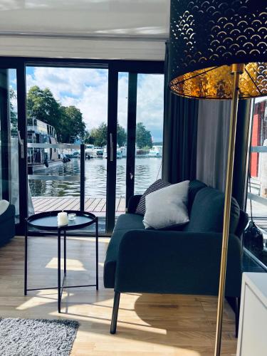 sala de estar con sofá y vistas al agua en Waterview - Schwimmendes Ferienhaus auf dem Wasser mit Blick zur Havel, inkl Motorboot zur Nutzung, en Fürstenberg-Havel