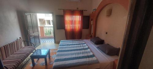 a large bed in a room with a couch at Maison Vallée Du Ziz in Ouled Aissa