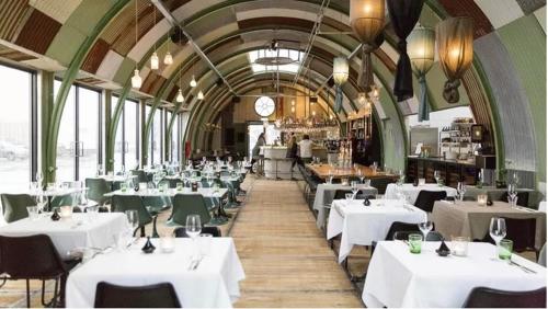 a dining room with white tables and green chairs at Studio 28A5 with free parking place in Amsterdam