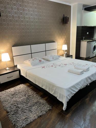 1 dormitorio con 1 cama blanca grande con alfombra en Studio Casa, en Galaţi