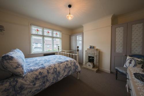 a bedroom with a bed and a fireplace and a window at Treblenick House in Thirsk