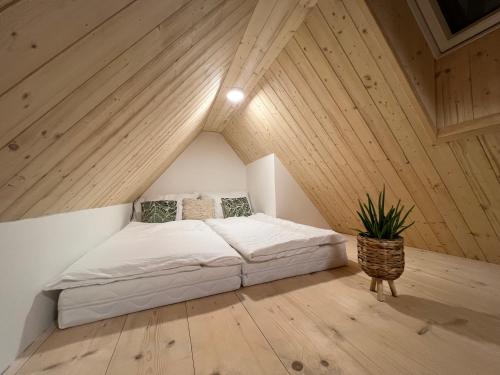 a bedroom with a bed in a attic at Apartmány NONE in Branná