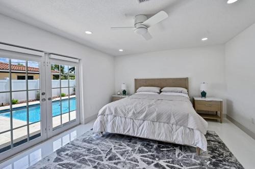 a bedroom with a bed and a swimming pool at Salt Life Beach Cottage Sleeps 8 Heated Pool in Pompano Beach