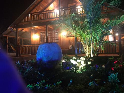 a garden in front of a house at night at Hostería los Cedros de Mindo in Mindo