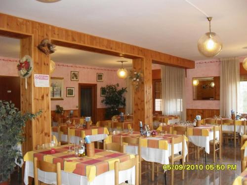 um restaurante com mesas e cadeiras num quarto em Hotel Montebaldina em San Zeno di Montagna