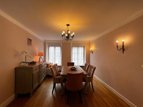 a dining room with a table and chairs at A La Maison - hébergement de luxe in Domfront