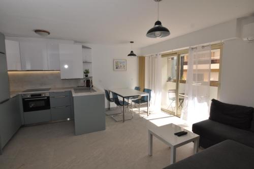 kuchnia i salon z kanapą i stołem w obiekcie Albert 1er · Chic One-Bedroom Apartment with Parking - StayInAntibes w mieście Antibes