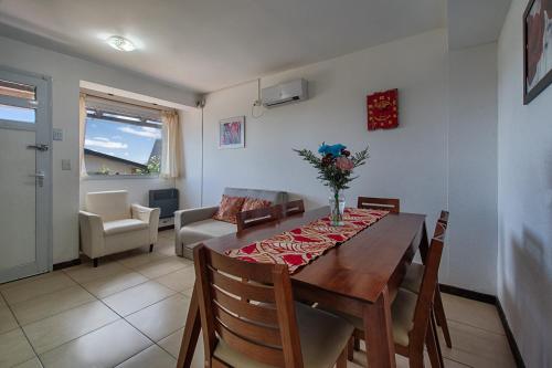 comedor con mesa y sillas y sala de estar en Departamento con vista al lago en Bariloche. en San Carlos de Bariloche