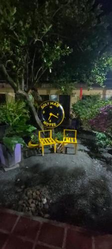 a yellow bench and a tree in a yard at Hotel Sol y Mar in Curumaní