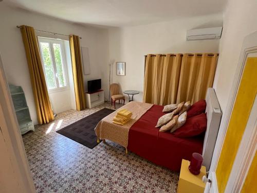 ein Schlafzimmer mit einem großen Bett und einem Fenster in der Unterkunft La maison Mortisson in Saint-Rémy-de-Provence