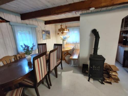 - une salle à manger avec un poêle à bois et une table dans l'établissement Domek nad jeziorem w otulinie lasu, à Bartołty Wielkie