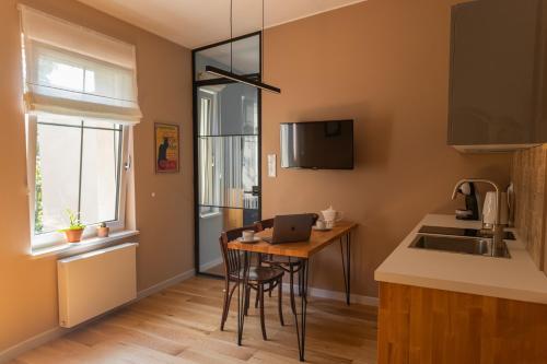 eine Küche mit einem Tisch und einem Laptop darauf in der Unterkunft Apartament Różana 21 in Posen
