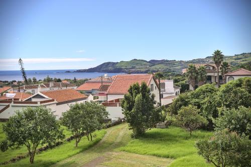 un pueblo con casas y árboles y el océano en Great View Apartment AL, en Porto Martins