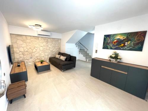 ein Wohnzimmer mit einem Sofa und einem Tisch in der Unterkunft Villa Lifestyle & Trends in Kástron