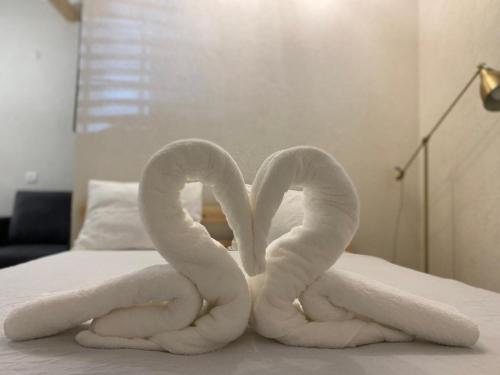 two towels shaped like swans sitting on a bed at Maya Guest House - German Colony & Baháí Gardens, Haifa in Haifa