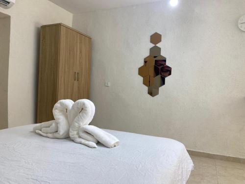 a bed with two white towels on top of it at Maya Guest House - German Colony & Baháí Gardens, Haifa in Haifa