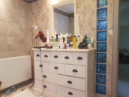 a bathroom with a dresser with a mirror at Story House 2 in Bragadiru