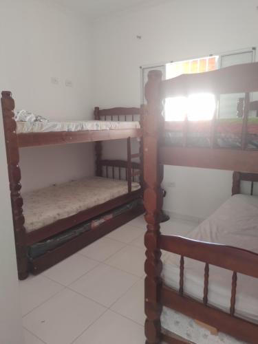 Dos literas en una habitación con una cama en Casa de Praia com piscina, en Mongaguá