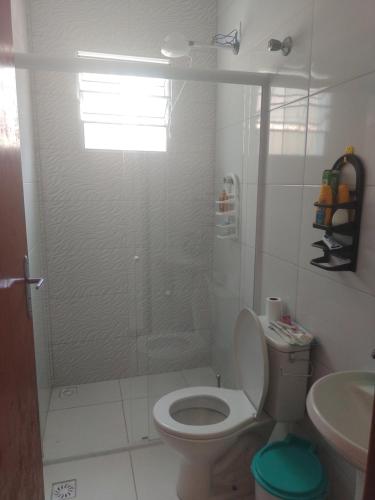 Un baño con ducha, inodoro y lavabo. en Casa de Praia com piscina, en Mongaguá