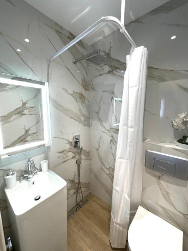 a bathroom with a white sink and a shower at Villa Lifestyle & Trends in Limenaria