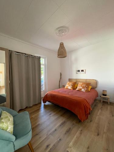 1 dormitorio con 1 cama grande con sábanas de color naranja en Un logement cosy proche des Ports, en Gujan-Mestras